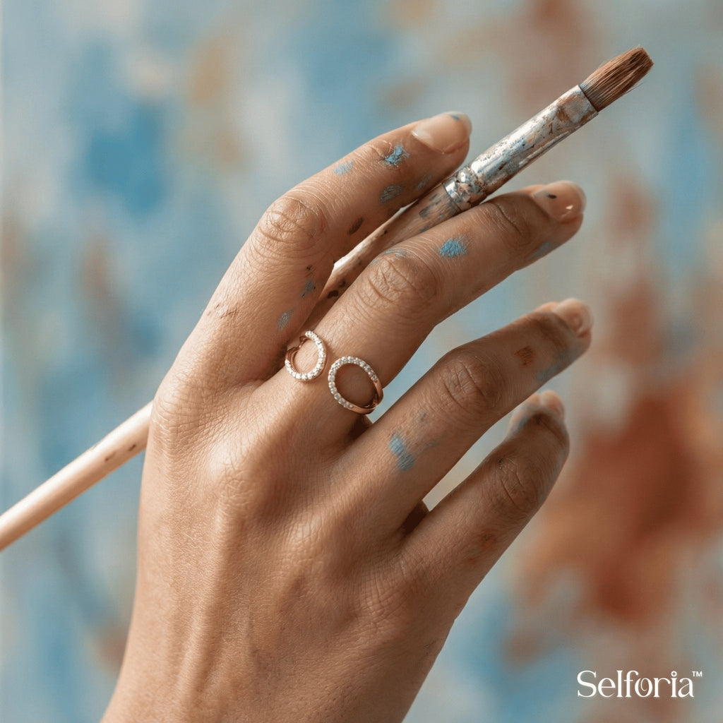 Woman wearing durable gold plated infinity ring during painting, crafted to resist tarnish and daily wear