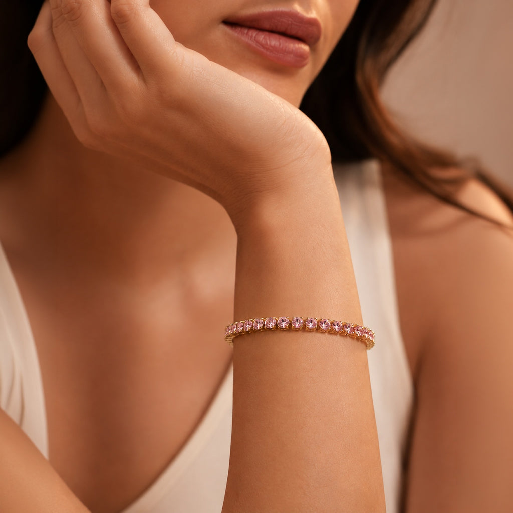 A close-up lifestyle shot of a model wearing a Selforia India Fashion jewellery delicate rose gold tone plated tennis bracelet with small pink gemstones on her wrist.