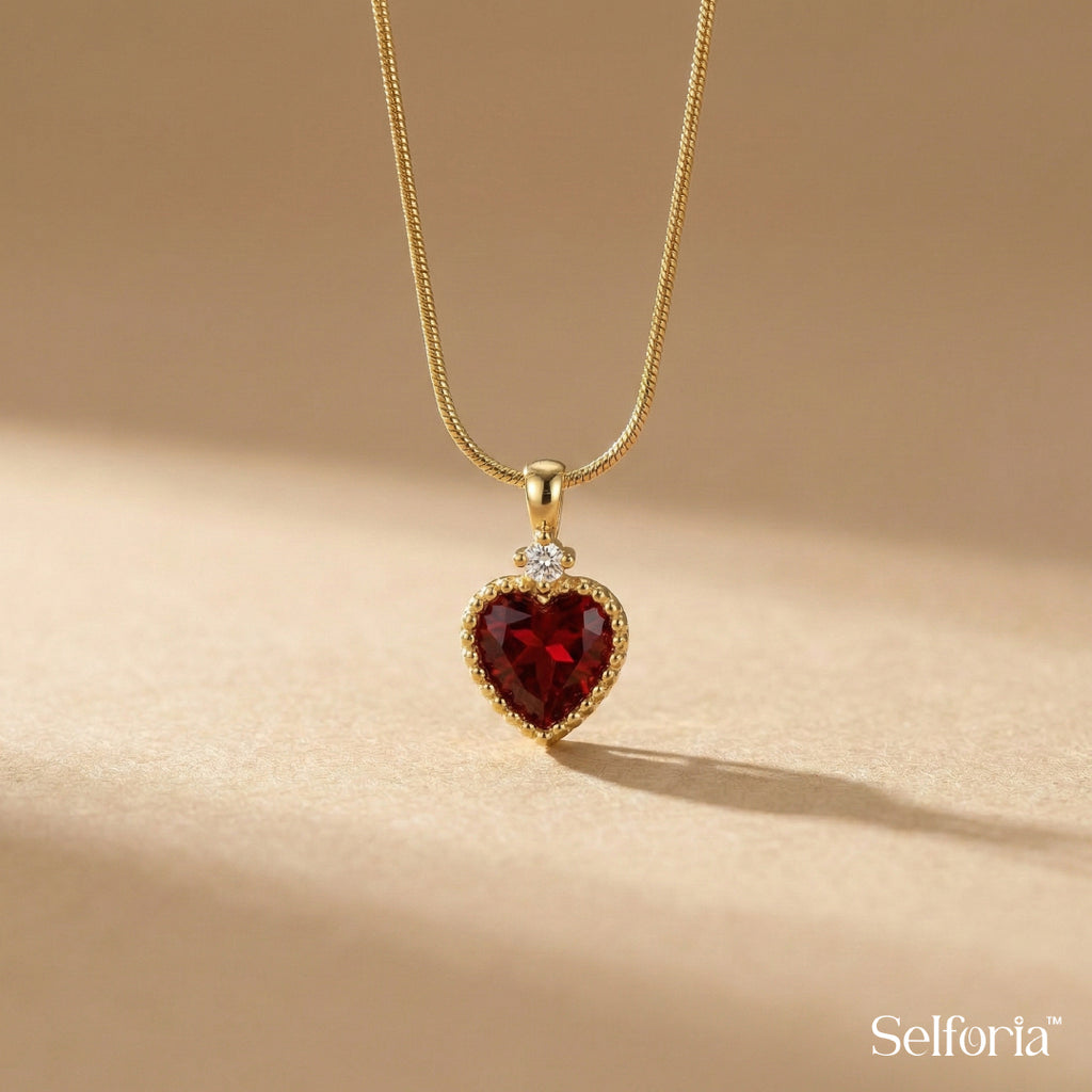 Close-up of red heart pendant necklace with gold finish