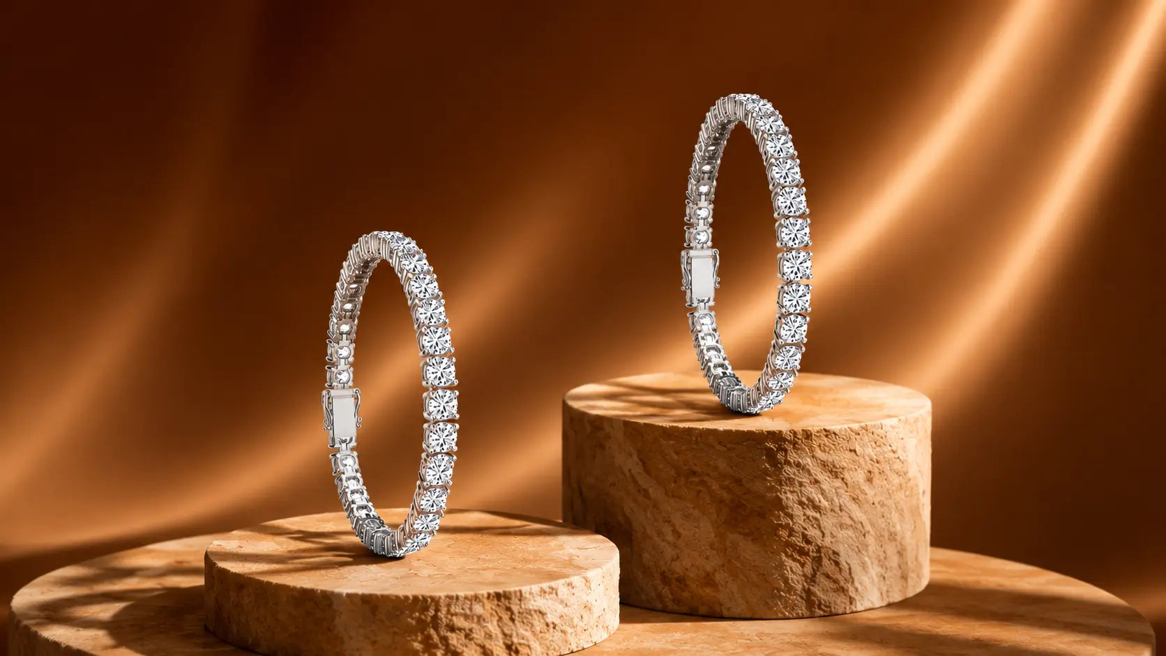 Two silver tennis bracelets for women encrusted with clear stones, displayed on round wooden pedestals against a warm brown satin background.